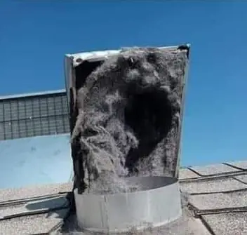 Dryer vent roof cap packed solid with grey lint