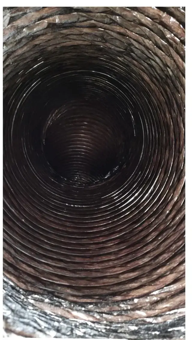 Inside a round flex duct lined with brown dust before cleaning