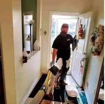 ABC technician coming through a client's front door with equipment